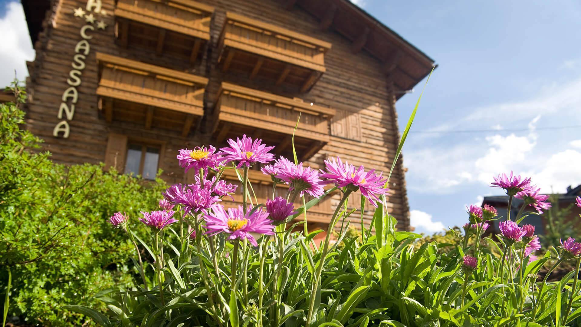 L’insegna Cassana sulla facciata in legno, con i fiori alpini in primo piano