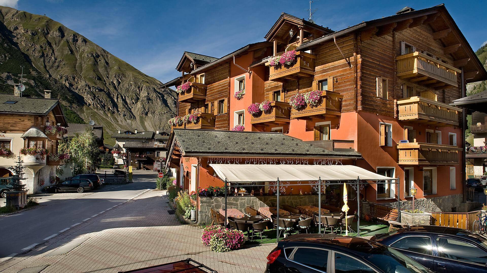L’Hotel Cassana in estate, con la terrazza e le montagne di Livigno
