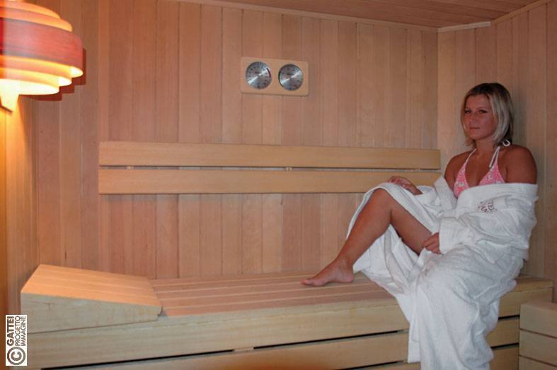 Ospite in accappatoio nella sauna finlandese in legno