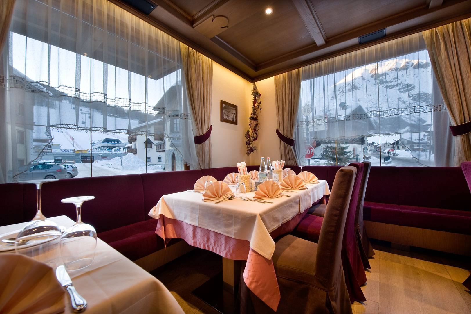 Tavolo apparecchiato accanto alla finestra, con la neve fuori