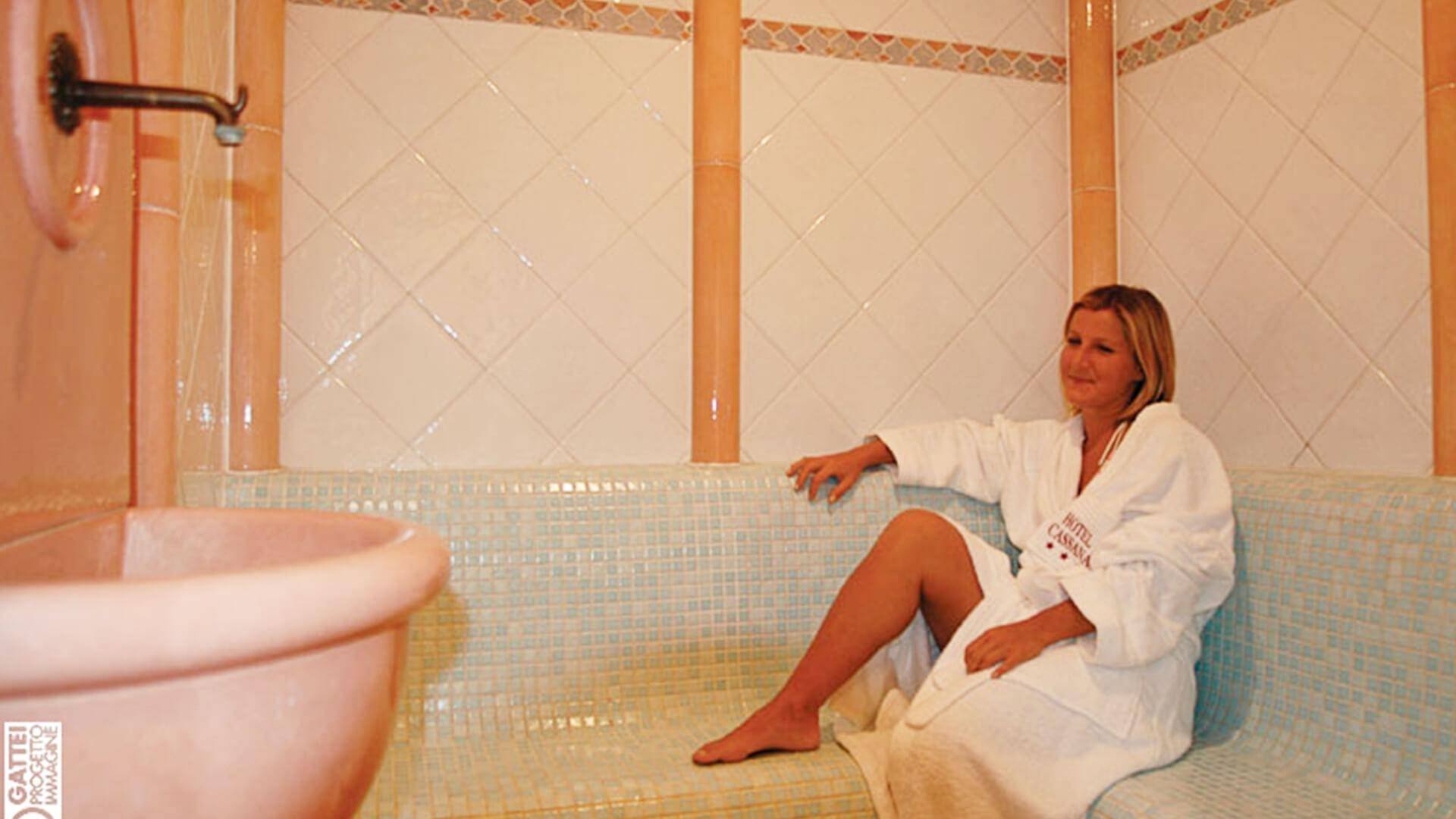 Ospite in accappatoio accanto alla vasca del wellness Punto Vita